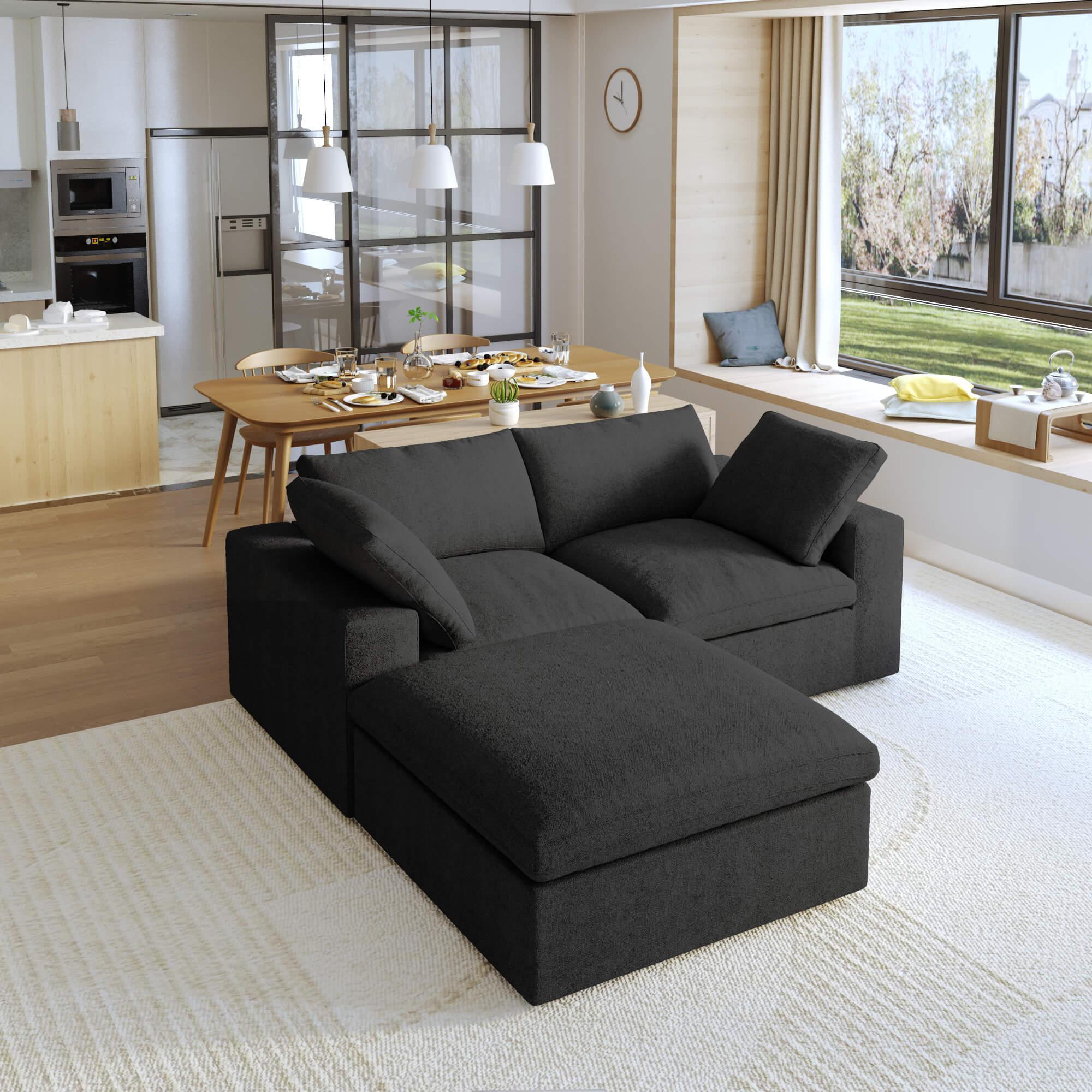 A black modular sectional sofa with a storage ottoman in a modern living room setting.