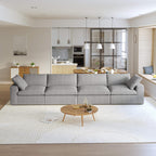 A modern gray sectional sofa in a living room setting, featuring a 4-seater configuration with a modular design, and down-filled cushions.