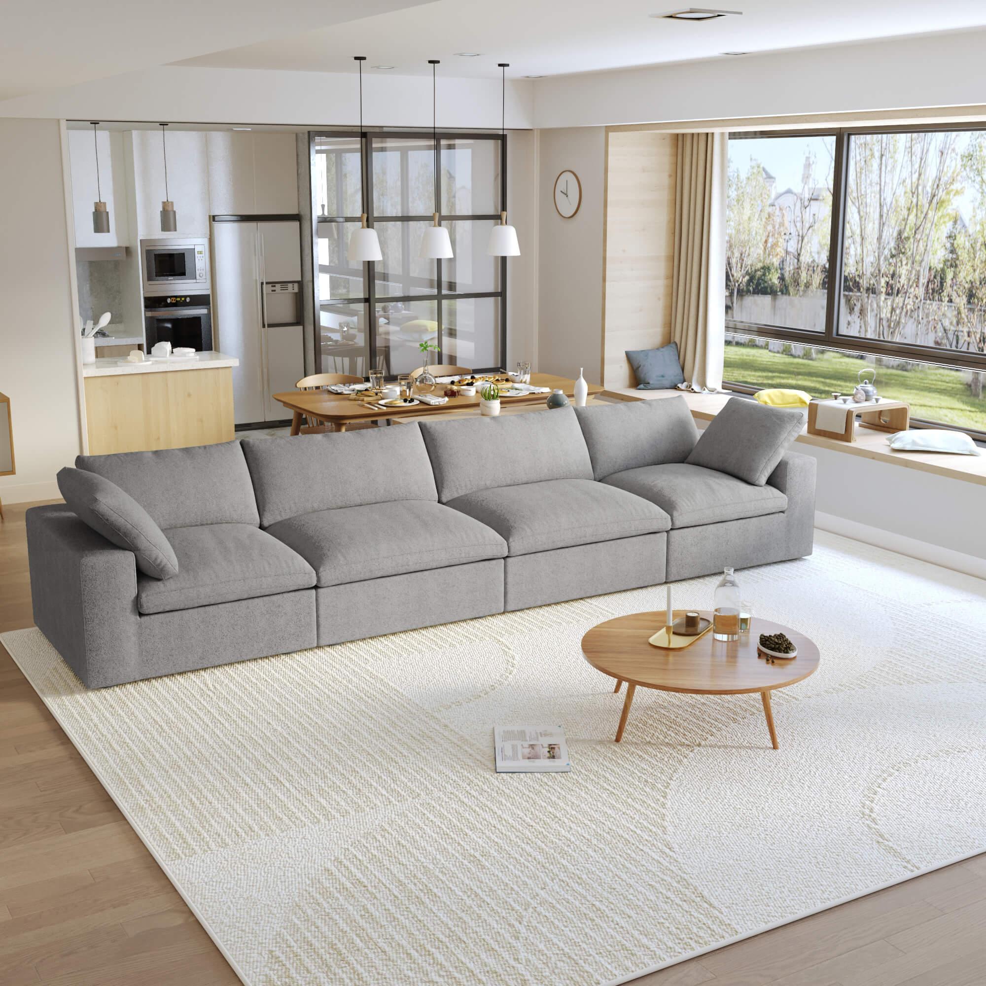 A modern gray sectional sofa in a living room setting, featuring a 4-seater configuration with a modular design, and down-filled cushions.