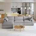 A gray L-shaped modular sectional sofa with a storage ottoman in a modern living room setting.
