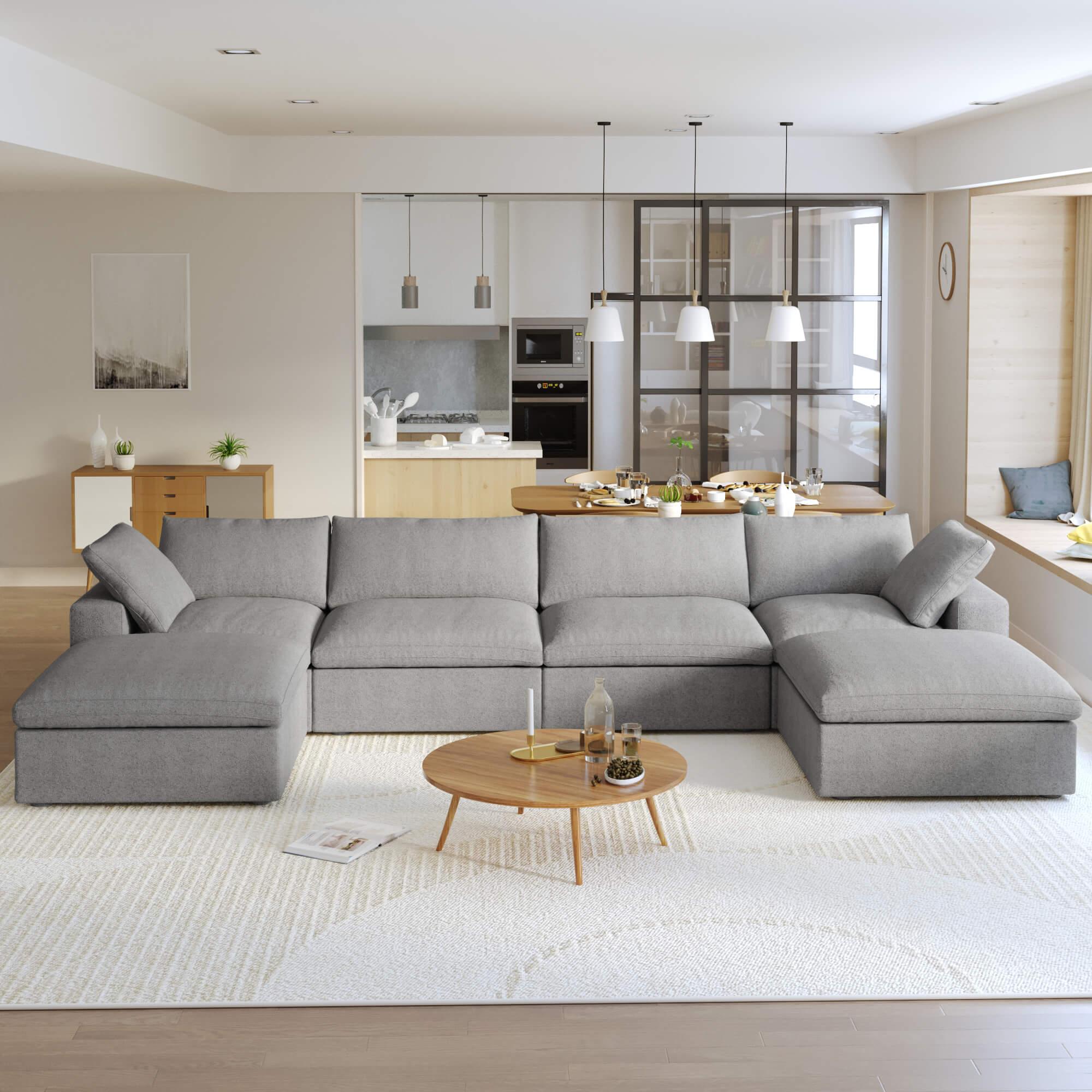 A large, U-shaped, gray modular sectional sofa with storage ottoman in a modern living room setting.