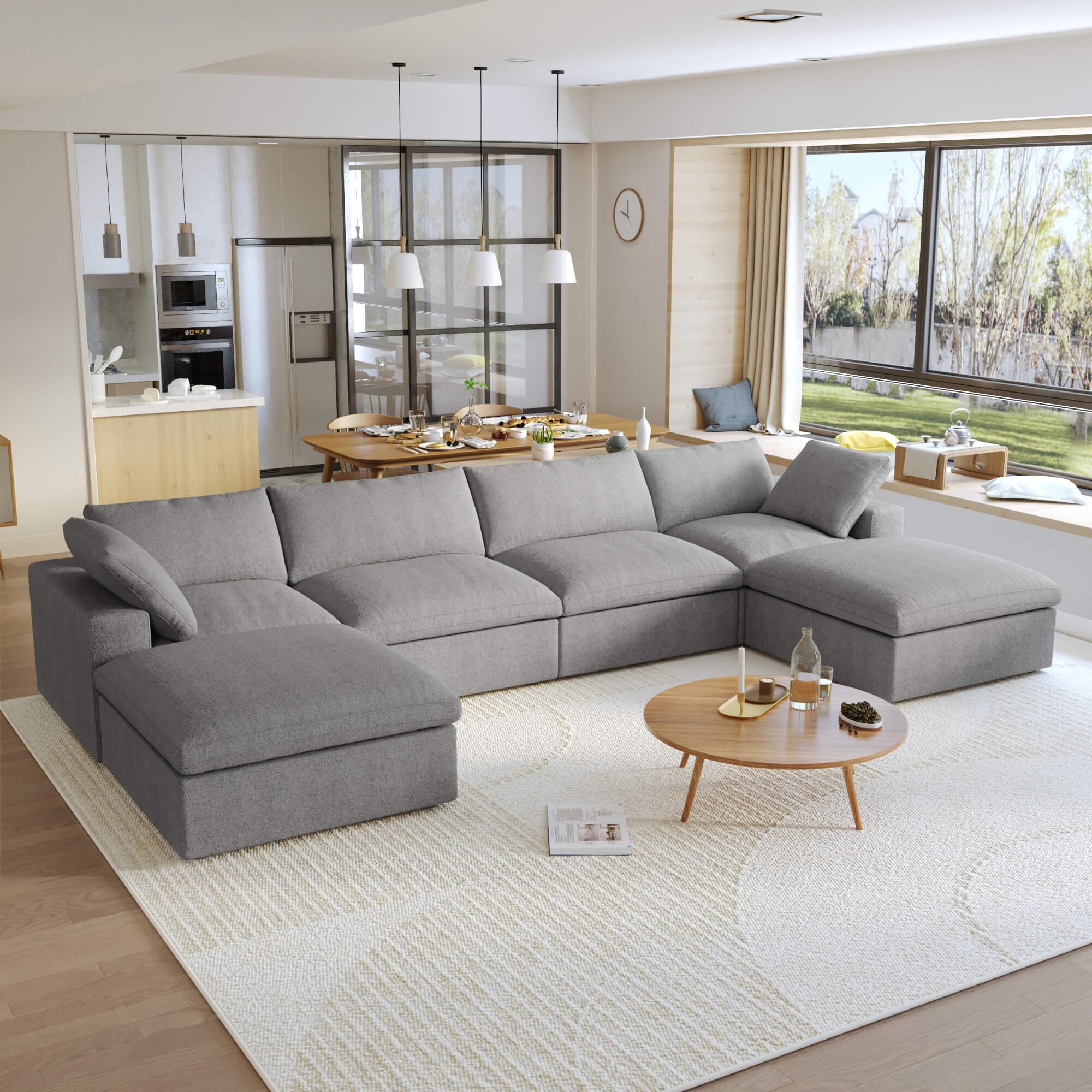 A large, U-shaped, gray modular sectional sofa with storage ottoman in a modern living room setting.