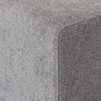Close-up of a corner of an armrest of a gray sofa