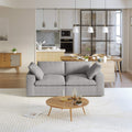 A modern gray loveseat sectional sofa in a bright living room setting, featuring a white slipcover, and designed for small space functionality.