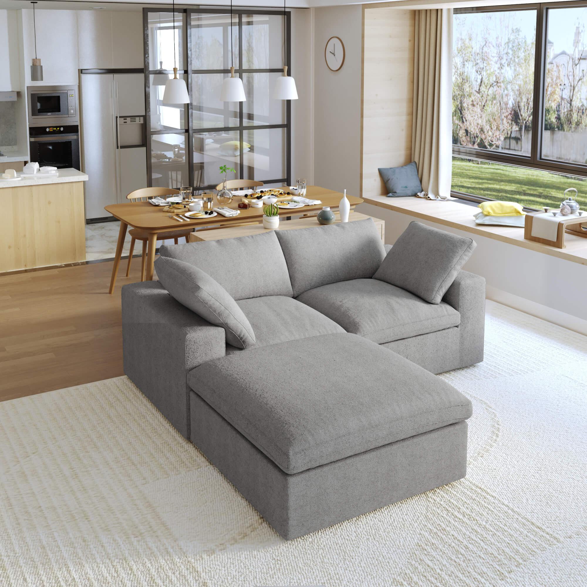 A gray modular sectional sofa with a storage ottoman in a modern living room setting.