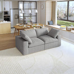 A modern gray loveseat sectional sofa in a bright living room setting, featuring a white slipcover, and designed for small space functionality.