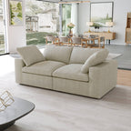 Khaki loveseat sofa in a modern living room with a dining area in the background