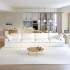 A modern sectional sofa in a living room setting, featuring a 4-seater configuration with a modular design, down-filled cushions, and a clean, white color scheme.