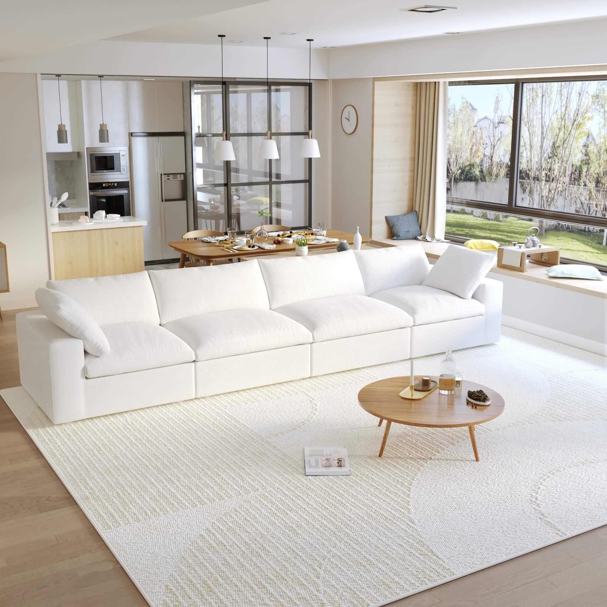 A modern sectional sofa in a living room setting, featuring a 4-seater configuration with a modular design, down-filled cushions, and a clean, white color scheme.