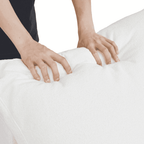 Person squishing a backrest cushion of a white sofa to show its softness
