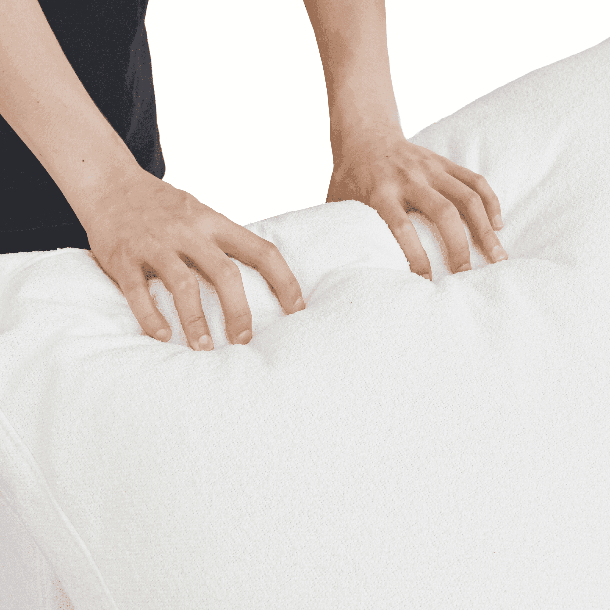 Person squishing a backrest cushion of a white sofa to show its softness