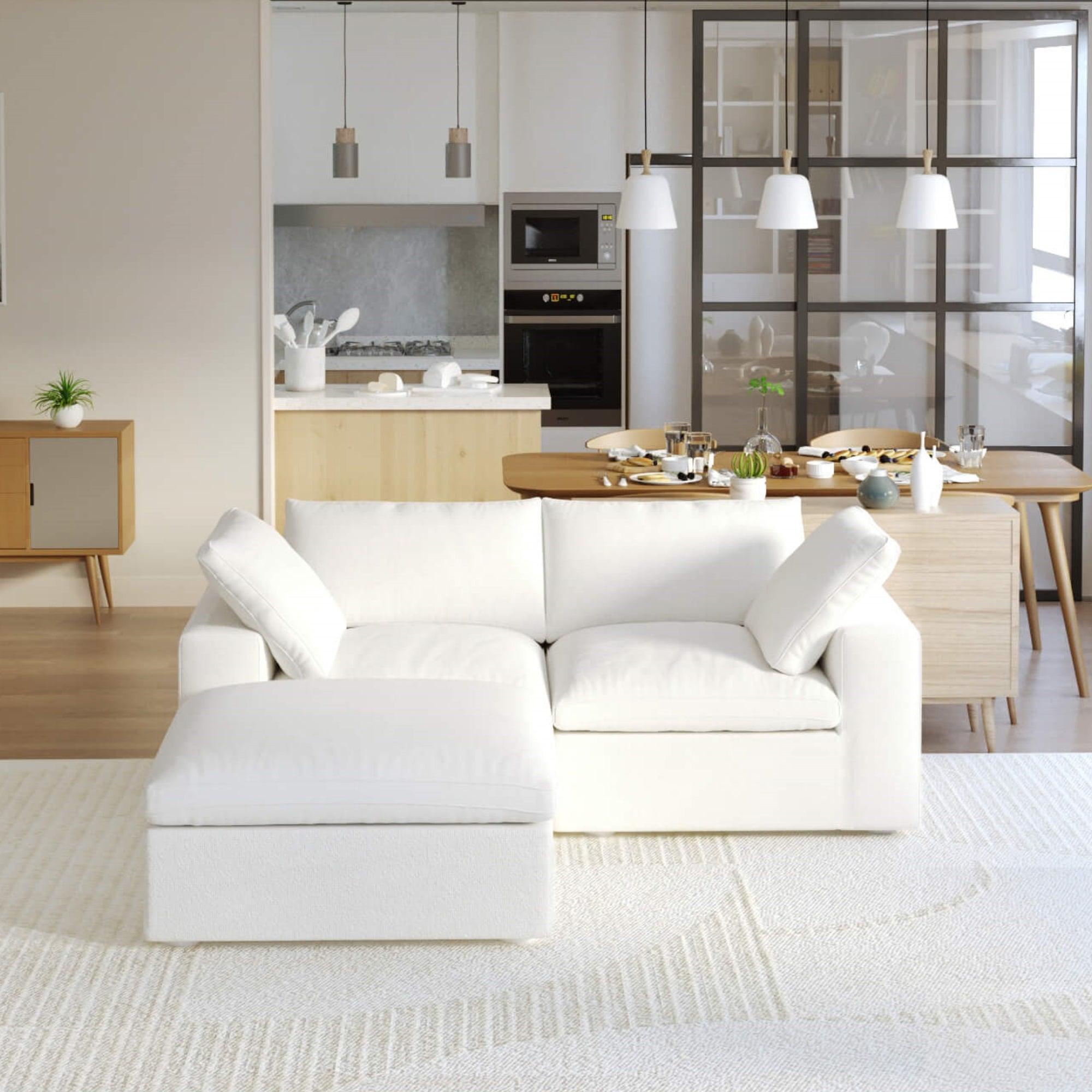 A white modular sectional sofa with a storage ottoman in a modern living room setting.
