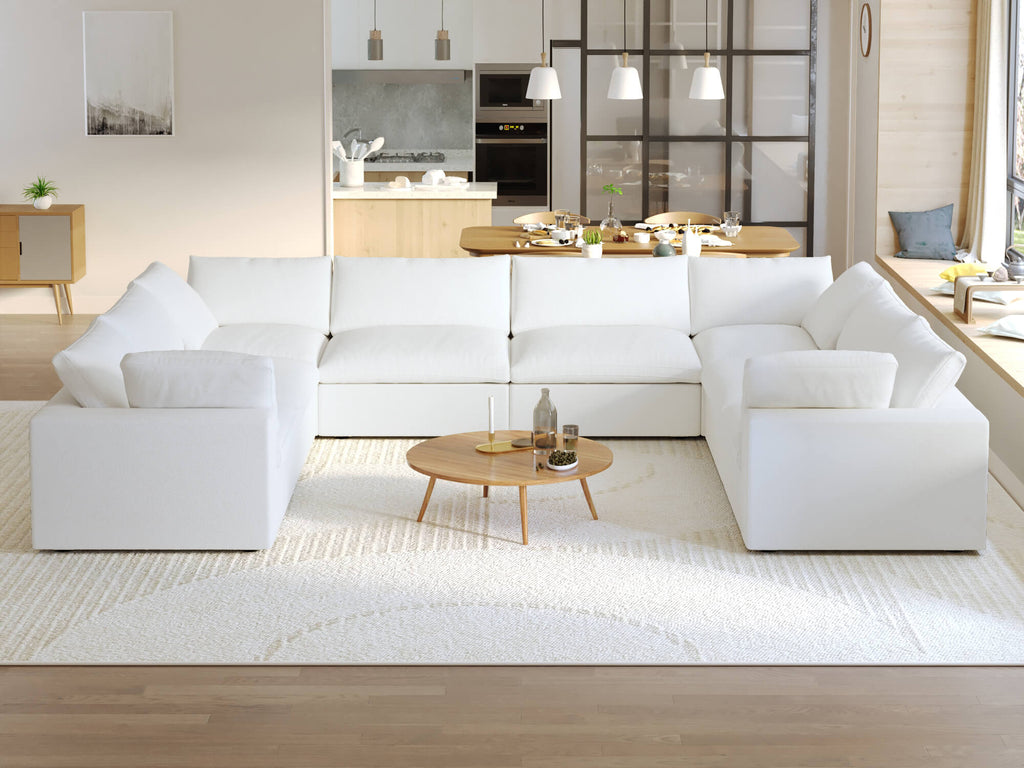 A modern, modular pit-style 8-seat sectional sofa in white in a living room setting with white cushions and a clean, contemporary design.