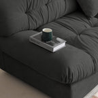 Close-up of a wide armrest of a gray suede sofa with book and a cup standing on it.