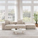 A beige corduroy 3-seat sectional lounger sofa with detachable armrests and removable covers, positioned in a bright room with large windows.