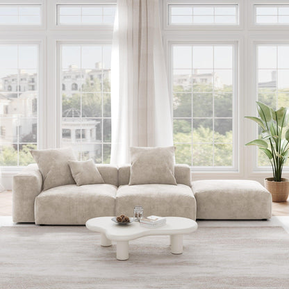 A beige corduroy 3-seat sectional lounger sofa with detachable armrests and removable covers, positioned in a bright room with large windows.