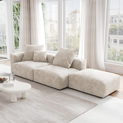 A beige corduroy 3-seat sectional lounger sofa with detachable armrests and removable covers, positioned in a bright room with large windows.