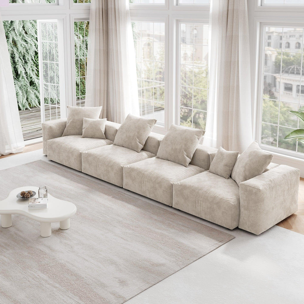 A beige corduroy 4-seat sectional modular sofa with detachable armrests and removable covers, designed to seat four people, displayed in a bright room with large windows.
