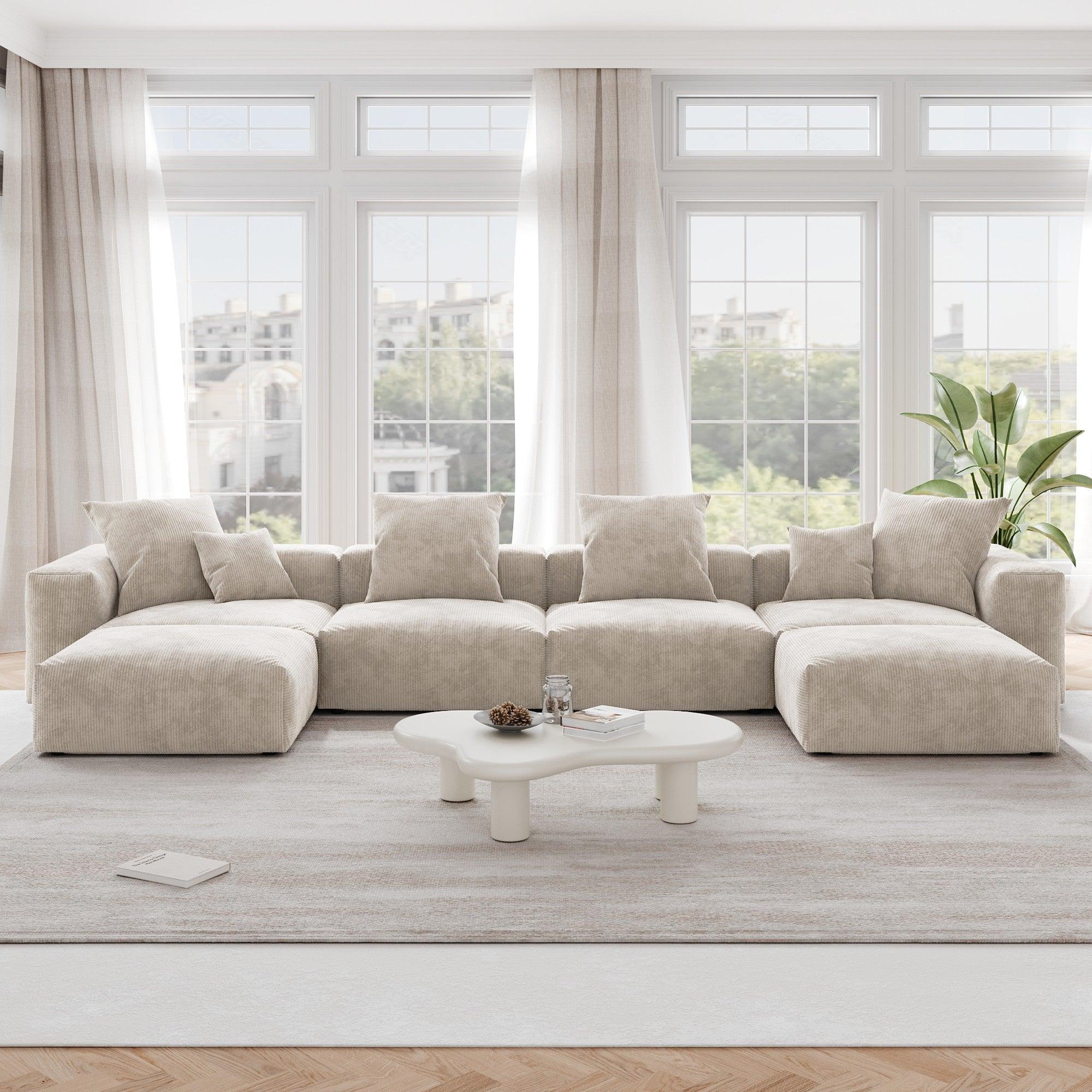 A beige corduroy modular sectional sofa with detachable armrests and removable covers, arranged in a U-shape configuration in a room with a light interior.