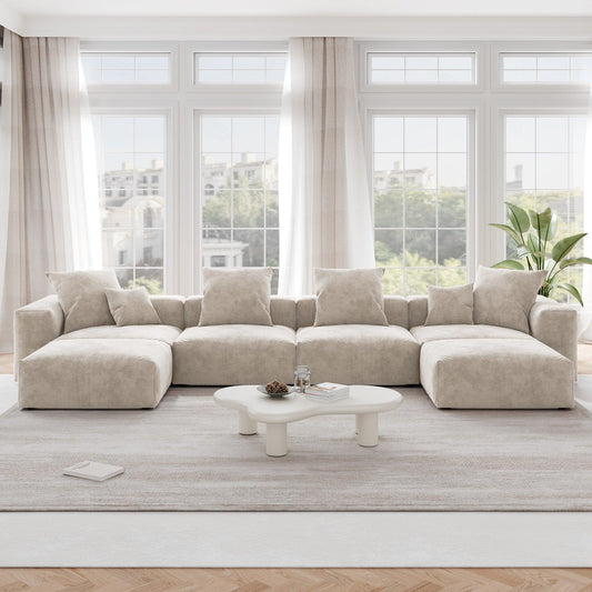 A beige corduroy modular sectional sofa with detachable armrests and removable covers, arranged in a U-shape configuration in a room with a light interior.