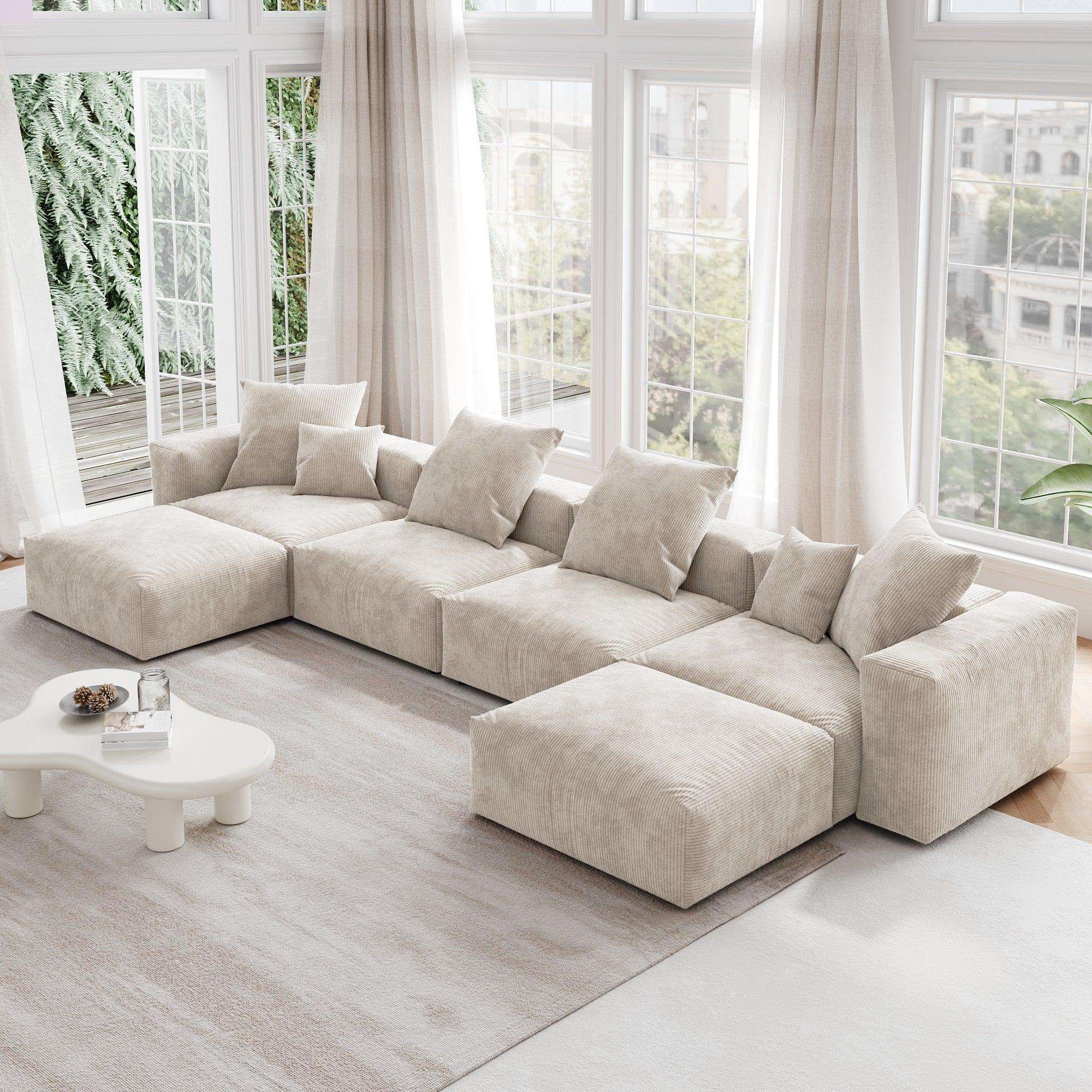 A beige corduroy modular sectional sofa with detachable armrests and removable covers, arranged in a U-shape configuration in a room with a light interior.