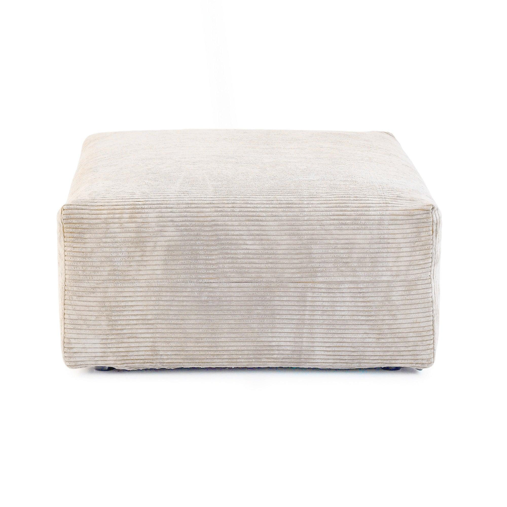 A beige corduroy modular ottoman with removable covers, presented in a minimalist style against a white background.