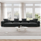 A black corduroy 4-seat sectional modular sofa with detachable armrests and removable covers, designed to seat four people, displayed in a bright room with large windows.
