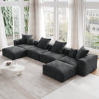 A black corduroy modular sectional sofa with detachable armrests and removable covers, arranged in a U-shape configuration in a room with a light interior.