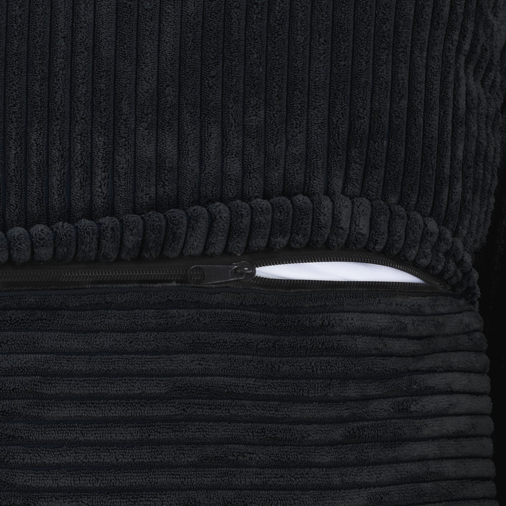 Close-up of a zipper on a cover of a black corduroy sofa