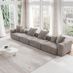 A brown corduroy 4-seat sectional modular sofa with detachable armrests and removable covers, designed to seat four people, displayed in a bright room with large windows.