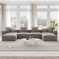 A brown corduroy modular sectional sofa with detachable armrests and removable covers, arranged in a U-shape configuration in a room with a light interior.