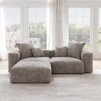 A brown corduroy sectional loveseat sofa with ottoman, detachable armrests, and removable covers, featuring a chaise lounge configuration placed in a room with large windows.