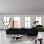 Modern living room with a black L-shaped sectional sofa, coffee table, and decorative elements.