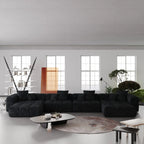 Modern living room with a large black U-shaped sectional sofa and decorative elements.