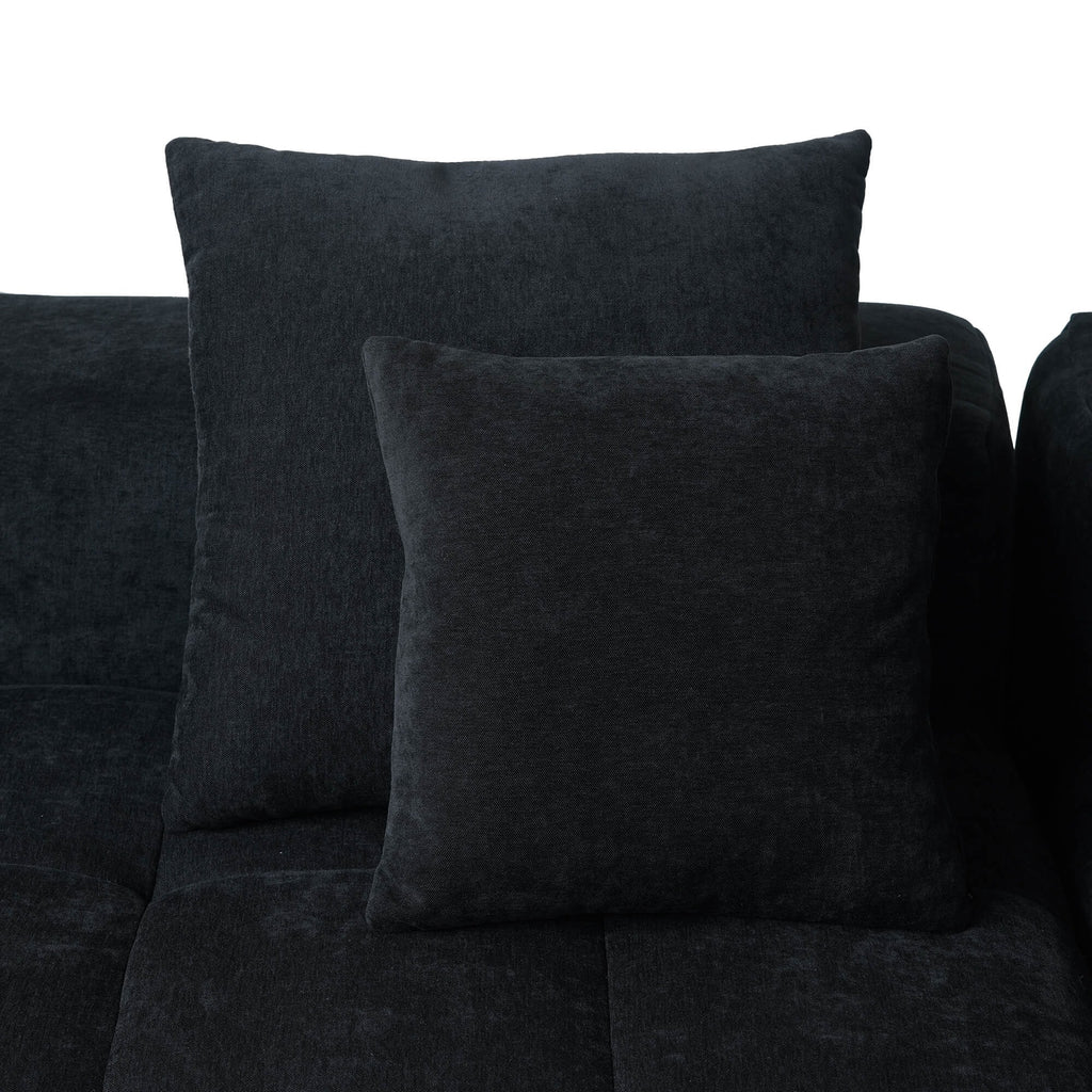 Two black accent pillows on a black sofa