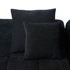 Two black accent pillows on a black sofa