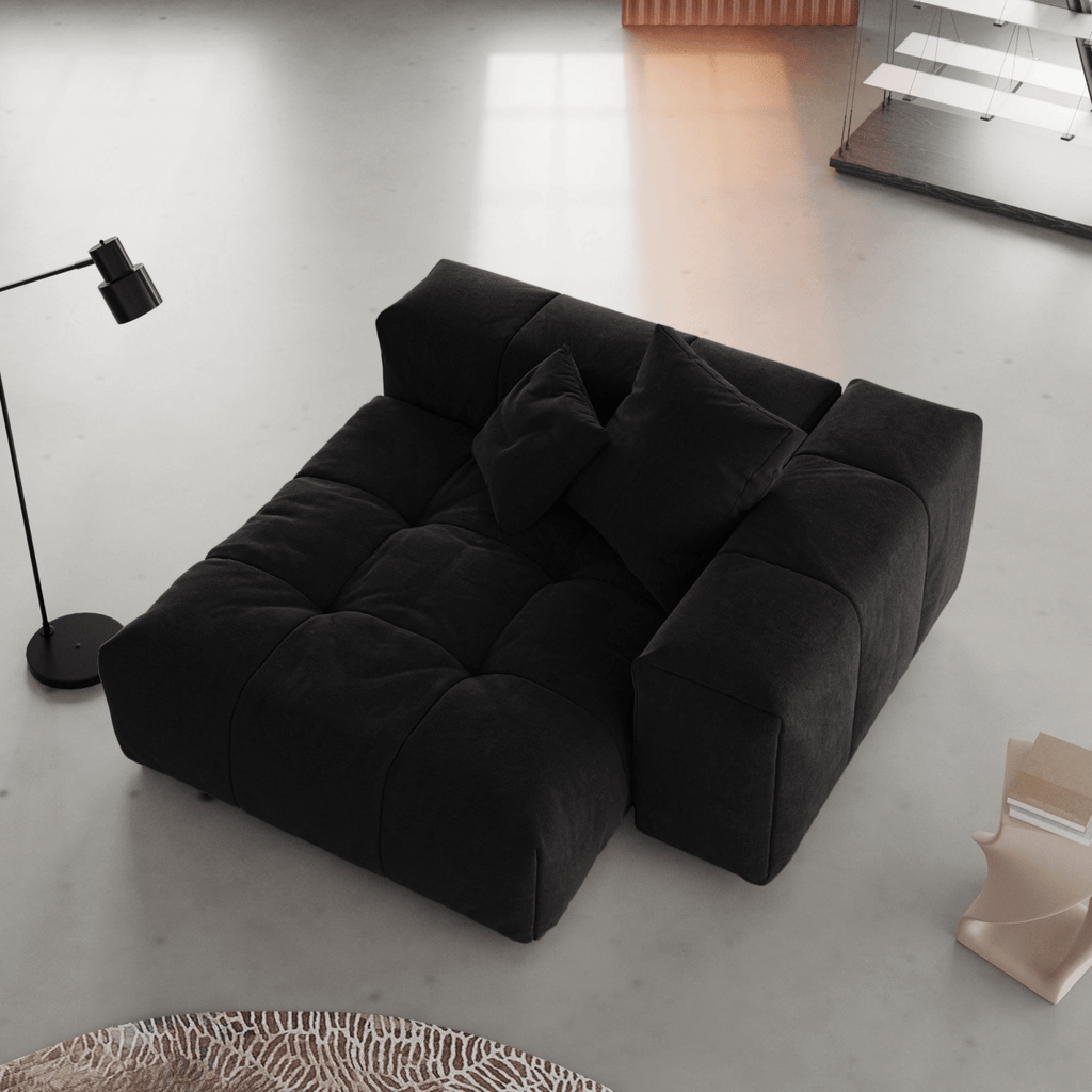 Black linen armrest chair in a minimalistic room with a lamp and rug.