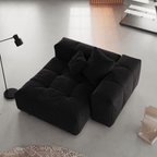 Black linen armrest chair in a minimalistic room with a lamp and rug.