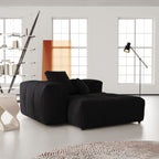 Modern black sectional deep armrest seat in a bright living room with large windows.