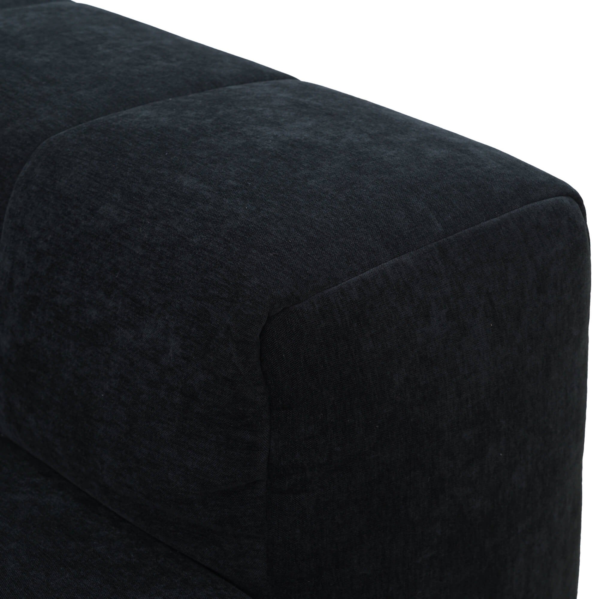 Close-up of a black upholstered armrest of a sofa