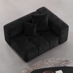 Black tufted left end chair on a light gray floor with a patterned rug.