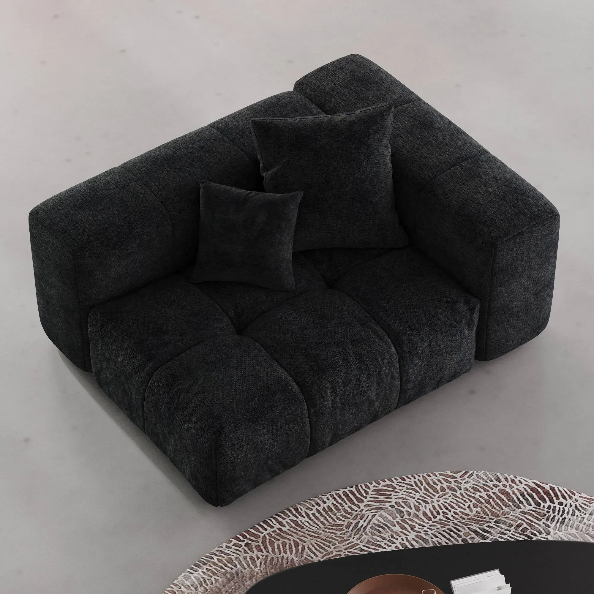 Black tufted left end chair on a light gray floor with a patterned rug.