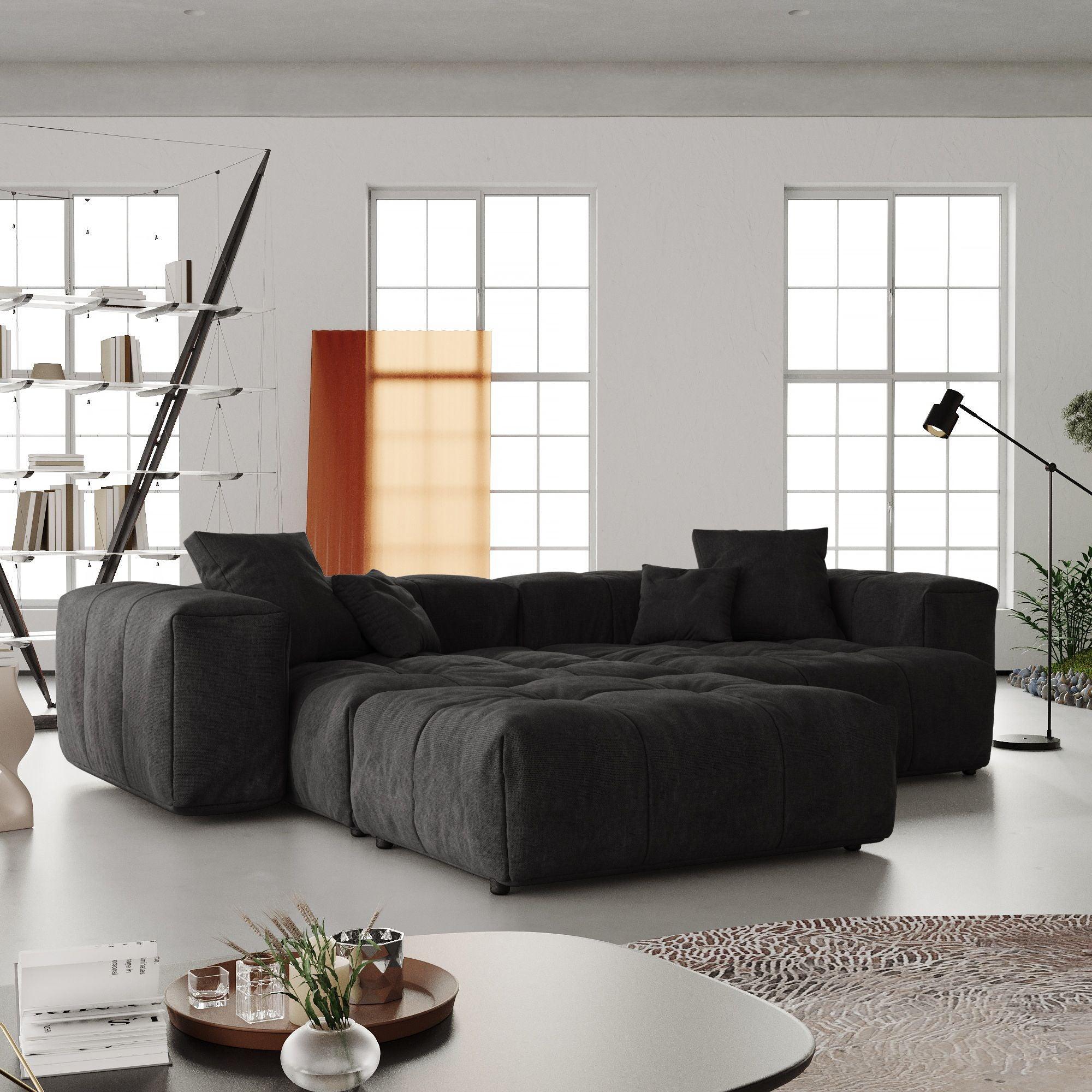 A modern black linen modular loveseat with ottoman in a bright room, featuring a white color scheme and minimalistic design.