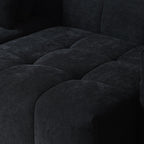 Close-up of a seat of a black tufted sofa