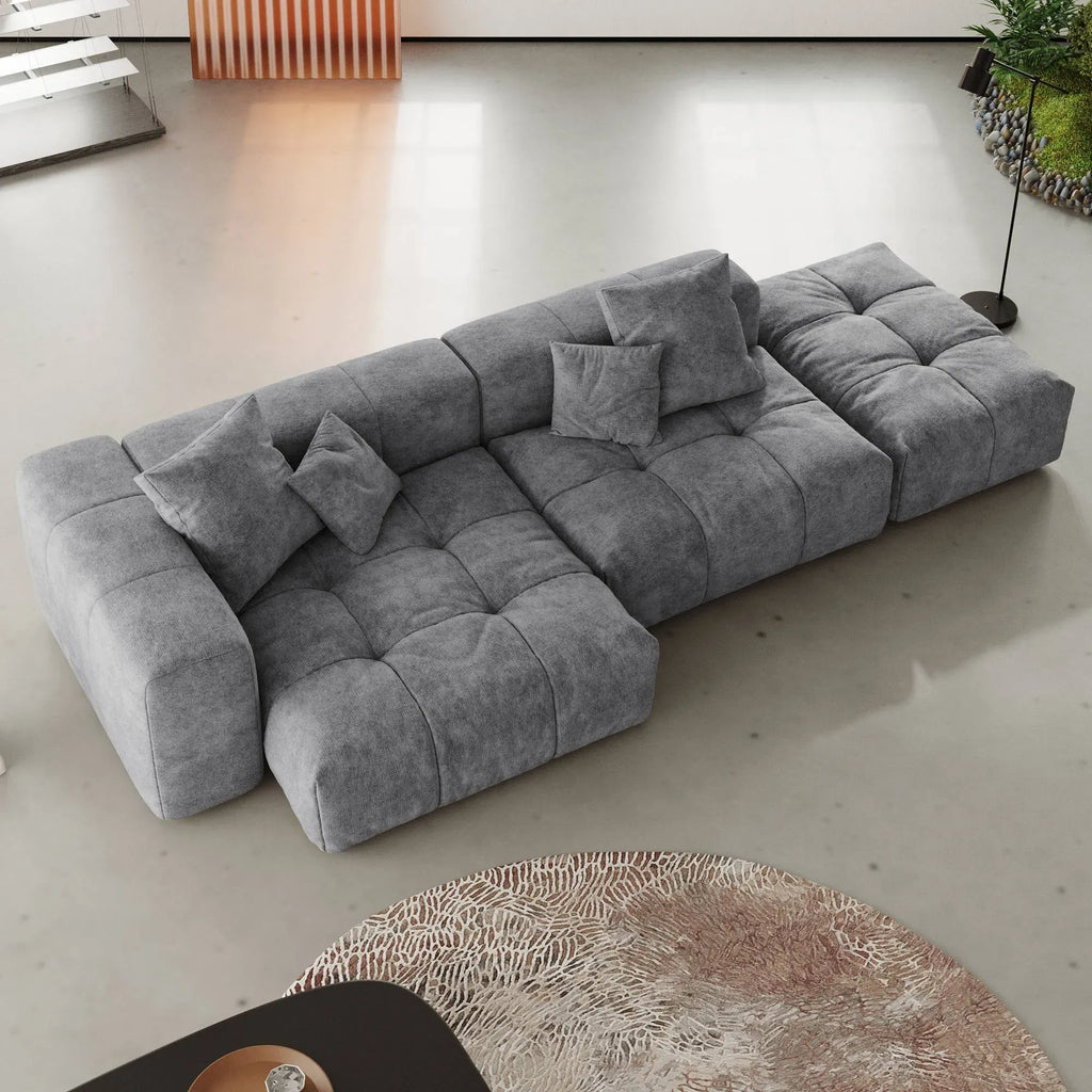 Gray 3-seat lounger sectional sofa in a modern living room setting with a round rug.