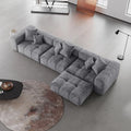 Gray L-shaped sectional sofa in a modern living room with a round rug and coffee table.