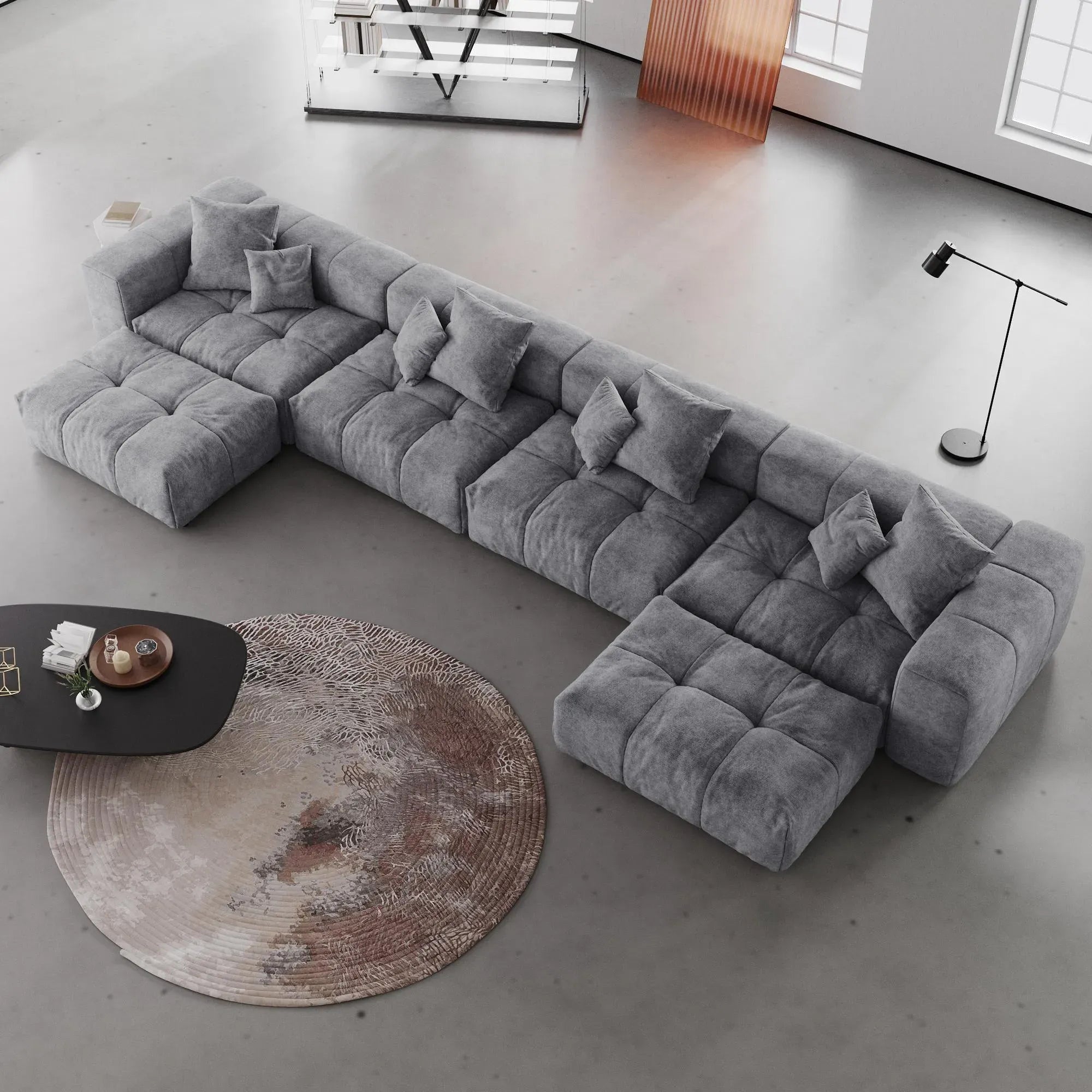 Gray U-shaped sectional sofa in a modern living room with a round rug and coffee table.