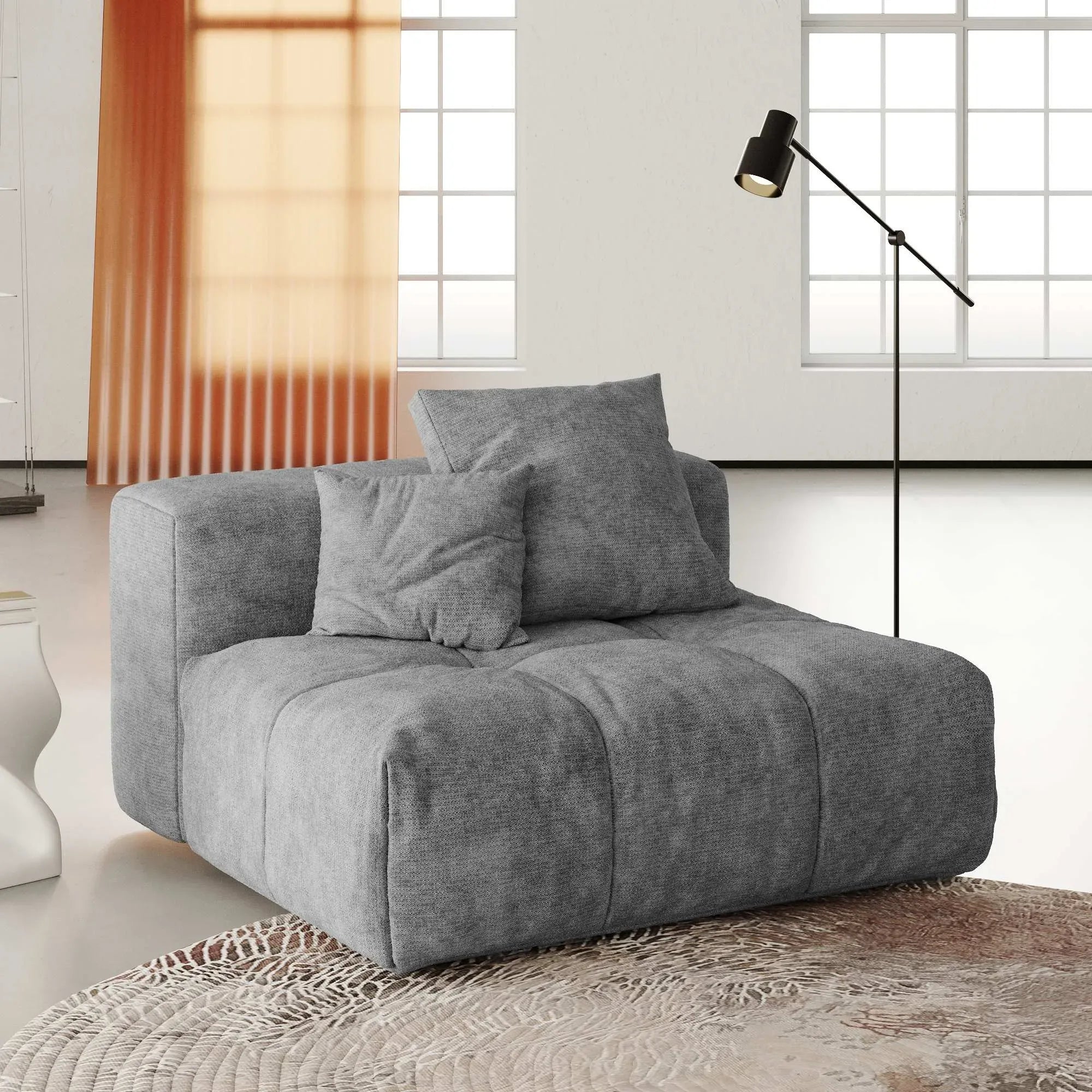 Gray armless chair with cushions in a modern living room setting