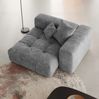 Gray extended end chair with cushions on a textured rug in a minimalistic room.