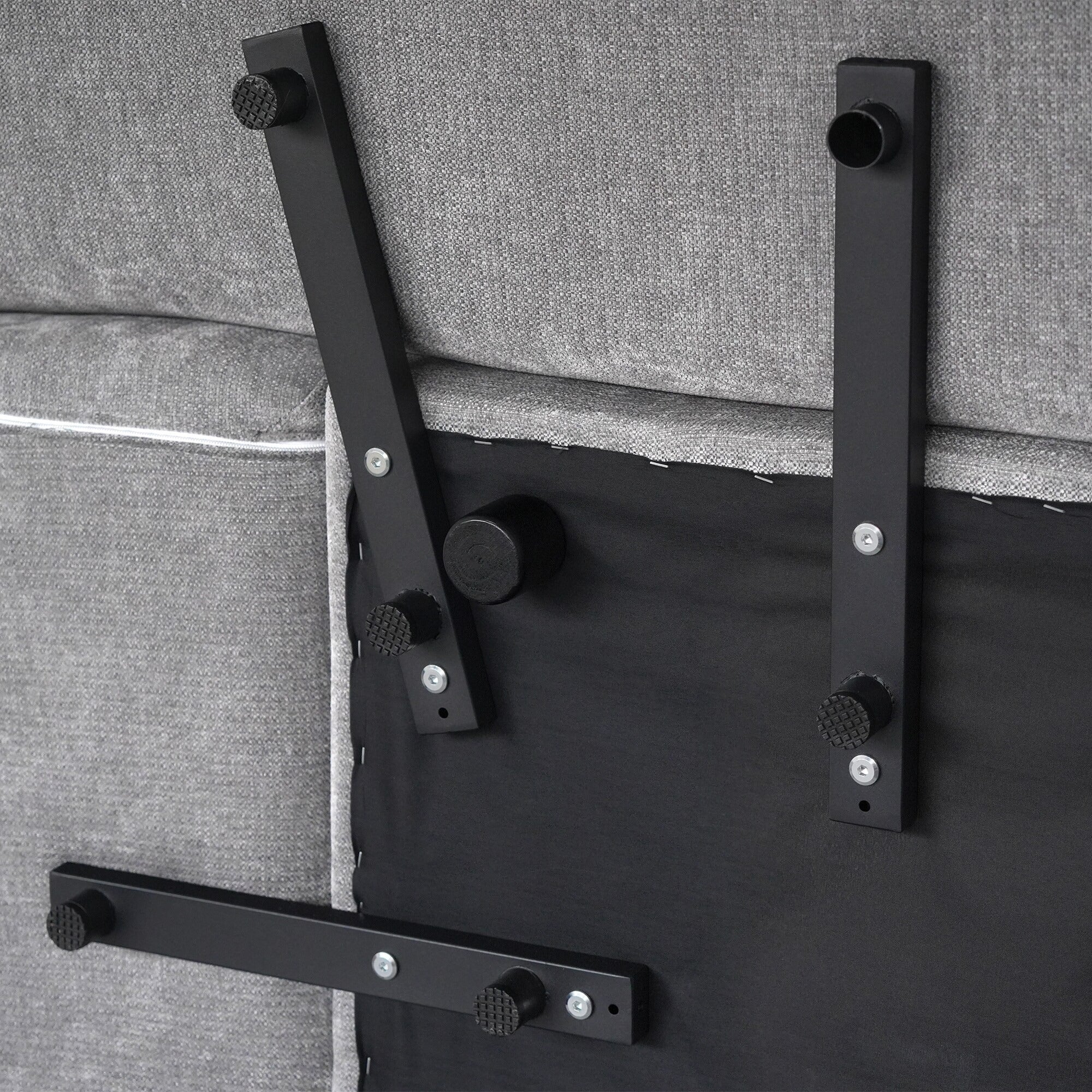 Underside frame and modular connectors of a gray linen sofa